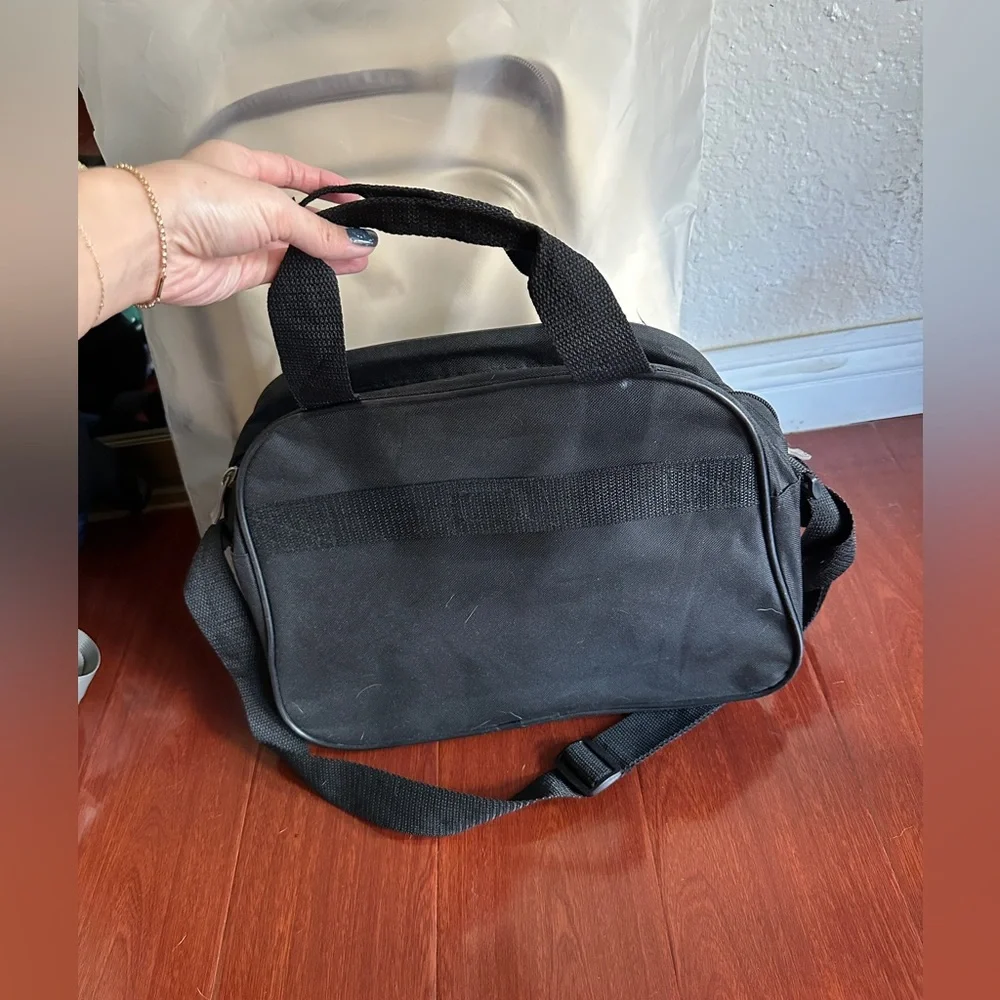 Men’s minimalist black carrying bag for travel or everyday use. Airplane logo.